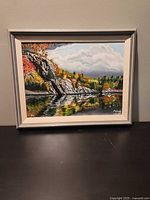 Full view of framed McGuff landscape painting on tabletop
