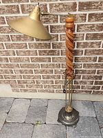 Full view of adjustable floor lamp against brick wall