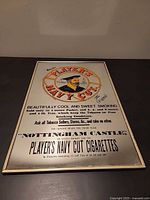 Full view of framed advertising mirror on flat surface