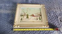 Framed painting with tape measure showing width