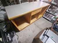 Angled view of full counter showing laminate top, wood base, open bays