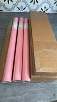 Three visible pink wrapping paper rolls next to boxed rolls