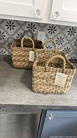 Two square seagrass baskets with tags front view