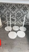 five white metal stands on countertop