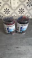 Two sealed tubs of Merangue pens on counter