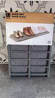 Front of boxed Umbra Shoe Dry shoe rack with grey rack visible