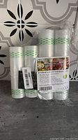 Four KitchenBoss vacuum sealer bag rolls wrapped together