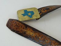 Buckle close-up showing Texas silhouette and leather tooling