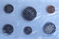 reverse sides of six coins in sealed pouch