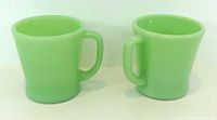 Front view of both jadeite mugs showing color and shape