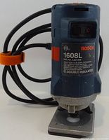 Front view of Bosch 1608L laminate trimmer with cord and base