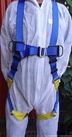 Front view of blue and yellow safety harness worn over coverall