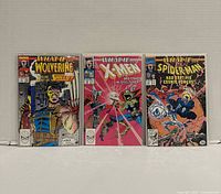Front covers of all three bagged comics displayed upright