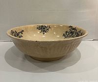 Side view showing full bowl shape, exterior ribbing and interior floral transfer