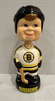 Front view of Boston Bruins bobblehead showing logo jersey, stick and base text