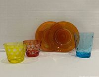 Group shot of all items: three tumblers and two amber plates