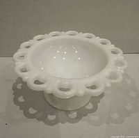 Top angled view of the milk glass bowl showing open lace rim and pedestal base