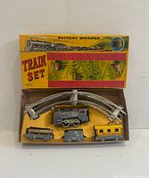 Entire train set in open box showing locomotive, three cars, three track pieces and box artwork