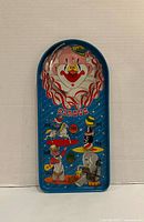 Full view of the blue tin Circus pinball game showing clown graphics and scoring layout