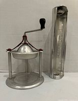 Front view of both aluminum kitchen tools: Handy Andy juice press and Reynolds Wrap dispenser