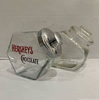 Front and side view of both glass jars, showing Hershey’s logo and unmarked jar