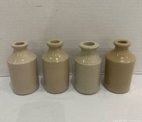 Front view of four stoneware bottles showing color variation and shape