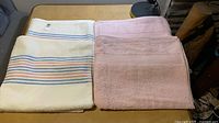 Stack showing striped towel next to pink towels