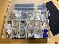 Overall view of plastic organizer with multiple compartments of bagged jewelry