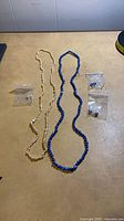 Full lot showing two necklaces and three bagged earring pairs