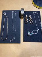 All seven jewellery items laid out on two foam pads