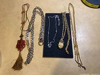 All five necklaces laid out on surface