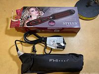 Box and brush with cord and pouch visible