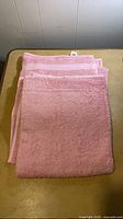 Folded pink bath towels stacked