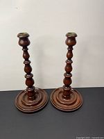 Front view of both turned wood candlestick holders on base