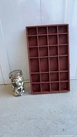 Wood tray standing upright beside jar of buttons