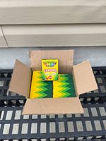 Open case showing 12 Crayola crayon boxes with one box upright