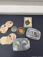 Full lot overview showing both belt buckles, coin, medallion, dairy caps and boxed pendant