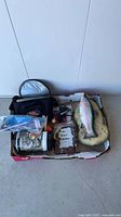 Box overview showing trout plaque, reel, line spool, bobbers, pouch, frame