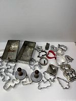 Full lot overview showing loaf pans, cookie stamps, numerous cookie cutters, teddy bear mold