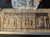 Full view of large horizontal papyrus painting with ruler for scale
