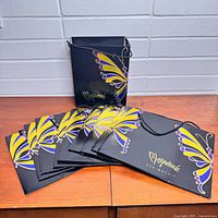 Group of paper bags standing and fanned out showing design and handles