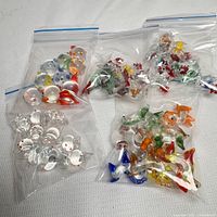 Four ziplock bags filled with assorted miniature glass animals