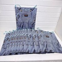 Stack of twelve striped OshKosh B'Gosh paper bags displayed flat