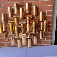 Front view showing full sculpture on brick wall