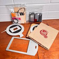 All items grouped: DeJur circular carrier, rectangular carrier, two sealed accessory bags