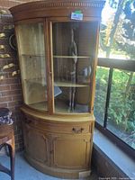 Full view of cabinet showing curved glass upper and wood lower sections