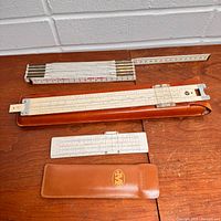 Overview of folding rule and two slide rules with cases