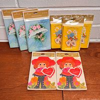 Front view of all eight sealed Hallmark stationery packs on table