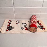 Towel unrolled beside tube showing graphics and size
