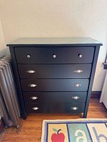 Front view showing all five drawers, hardware, and glass top